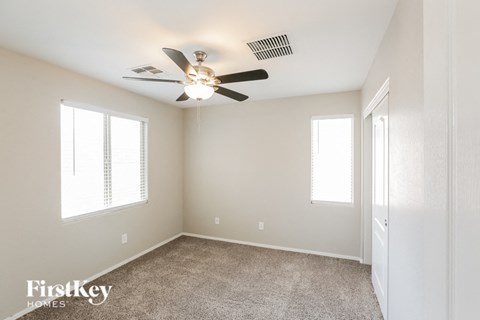 a bedroom with a ceiling fan and a door to a closet