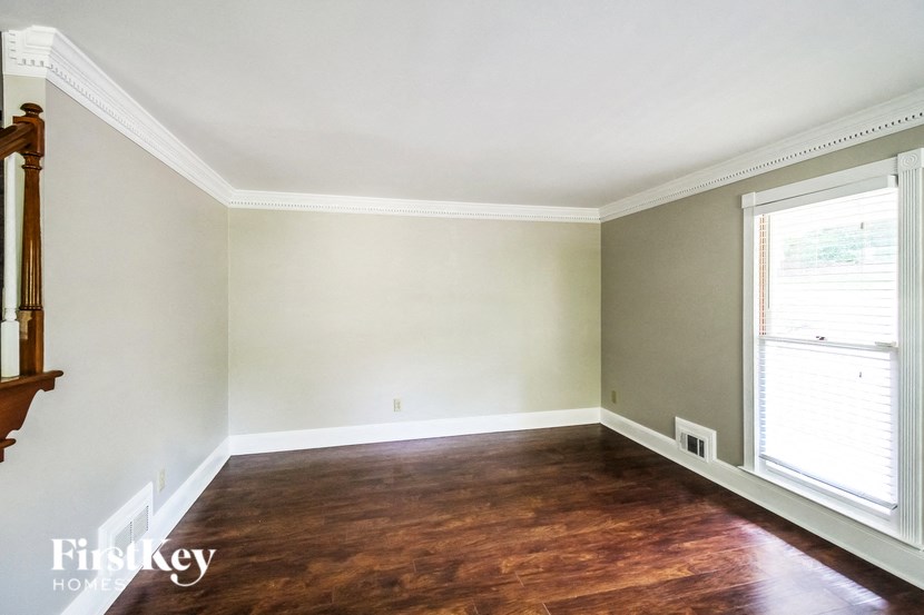a empty living room with wood floors and white walls