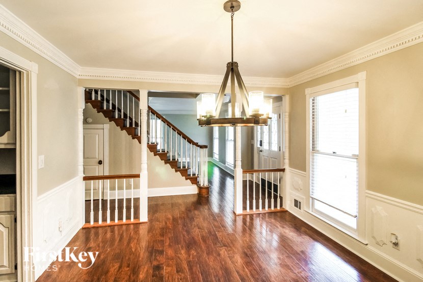 a living room with a staircase and a chandelier