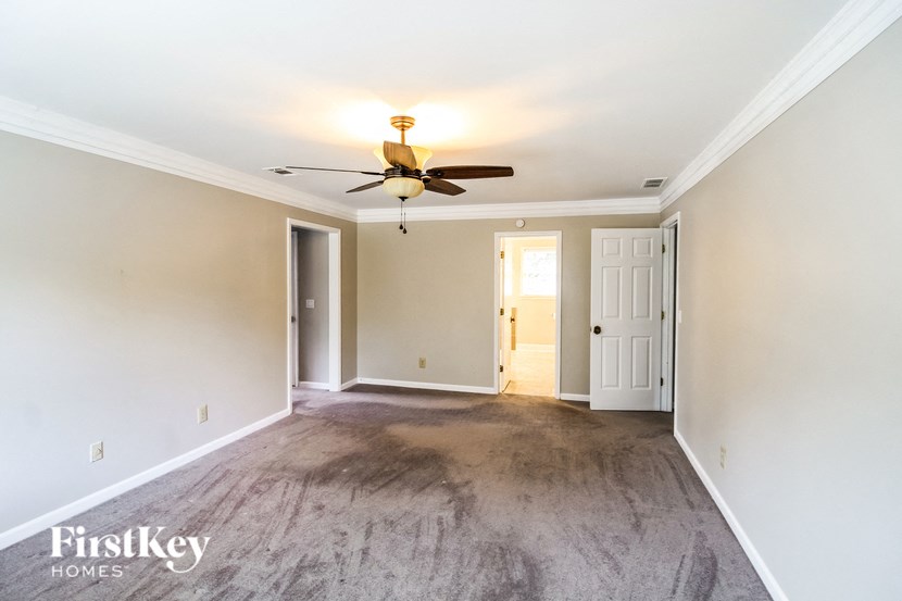 a empty living room with white walls and a ceiling fan