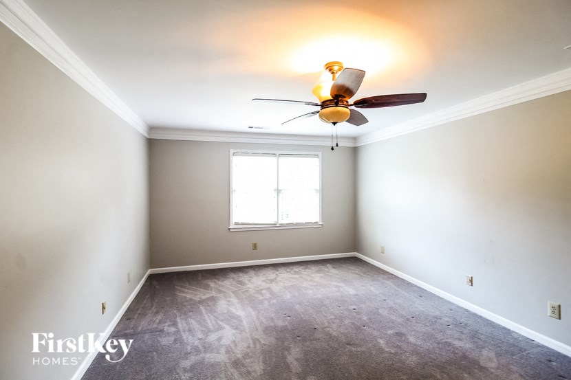 a empty room with a ceiling fan and a window