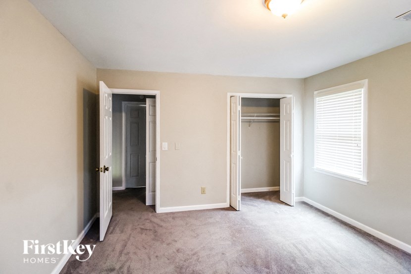 an empty living room with three doors and a closet
