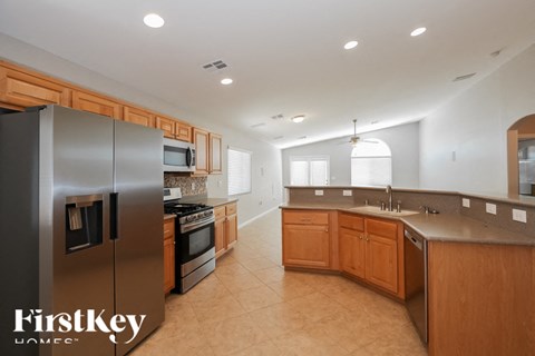 A modern kitchen with wooden cabinets and a stainless steel refrigerator.