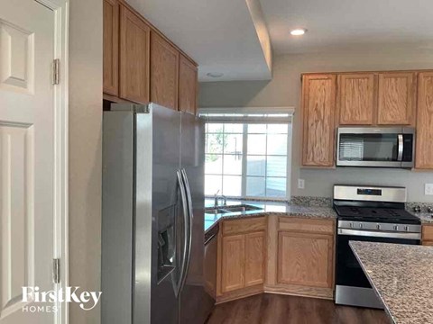 A kitchen with wooden cabinets and a stainless steel refrigerator.