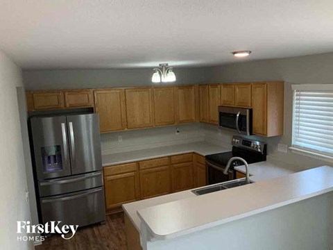 A kitchen with wooden cabinets and a stainless steel refrigerator.