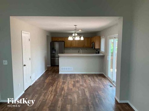 A kitchen with wooden floors and a white fridge.