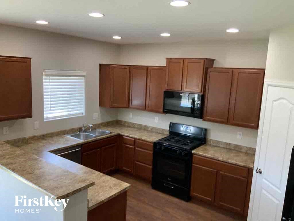 A kitchen with brown cabinets and a black stove top oven.