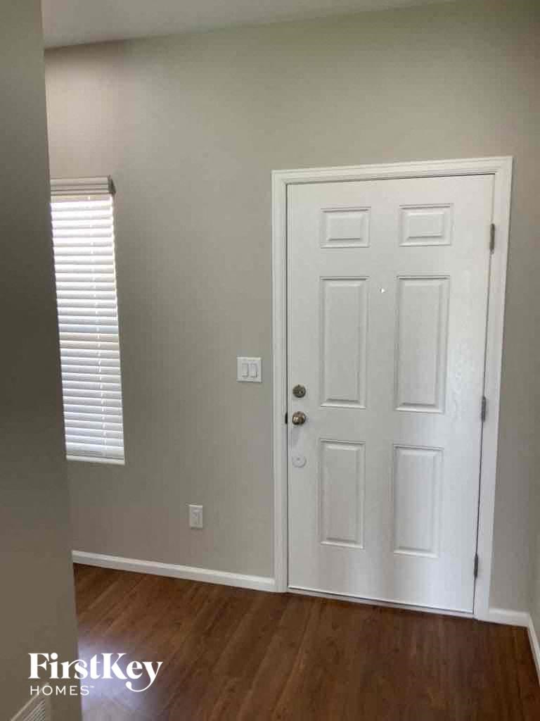A white door in a room with wooden floors.