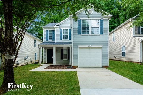 a blue and white house with a sidewalk in front of it