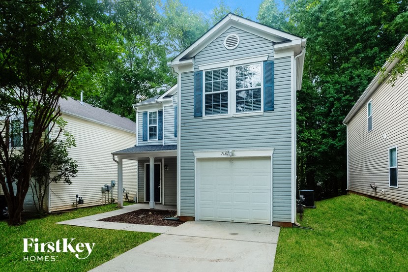 a blue house with a garage and a driveway