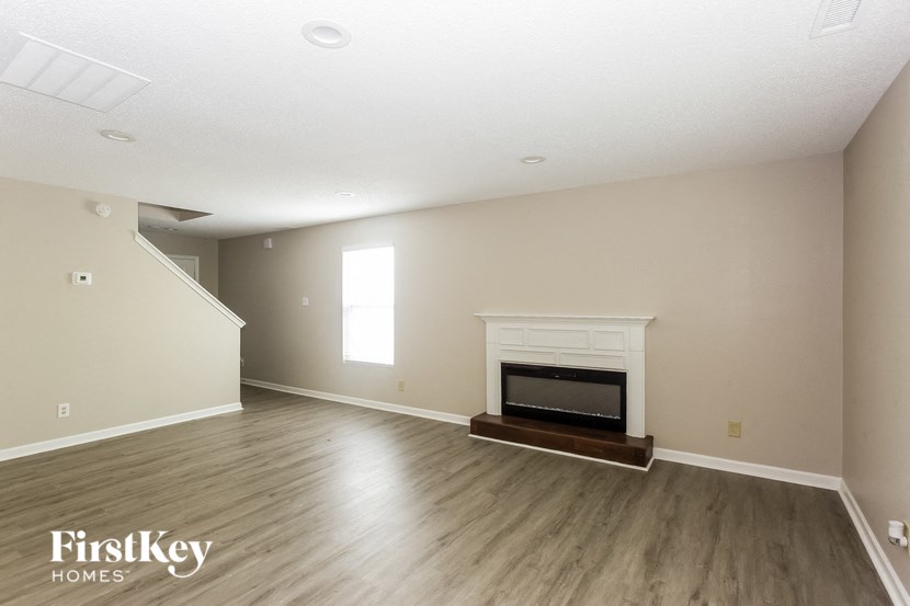 a living room with a fireplace and wooden floors