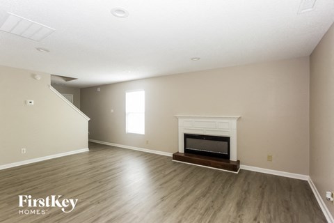 a living room with a fireplace and wooden floors