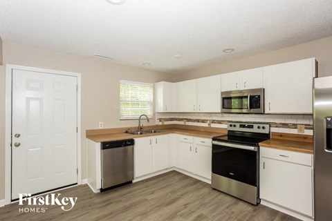 a kitchen with white cabinets and stainless steel appliances