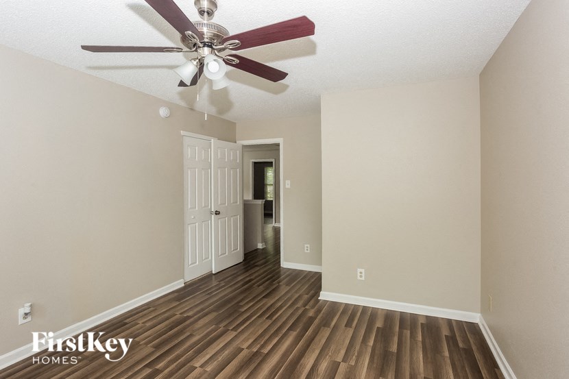 the living room of an empty house with a ceiling fan