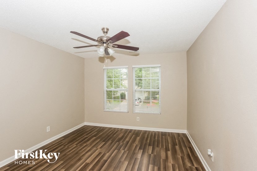 an empty room with a ceiling fan and a window