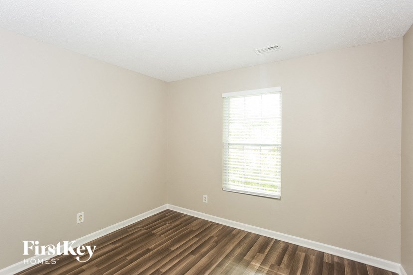 the living room of a house with a wooden floor and a window