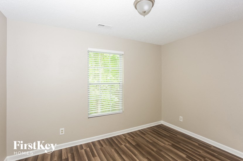 an empty room with a window and wooden floors