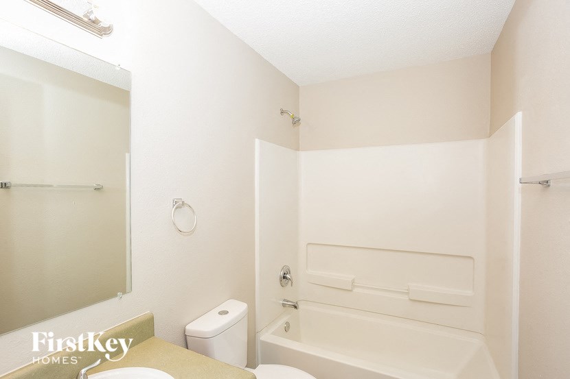 a white bathroom with a tub and a toilet and a sink