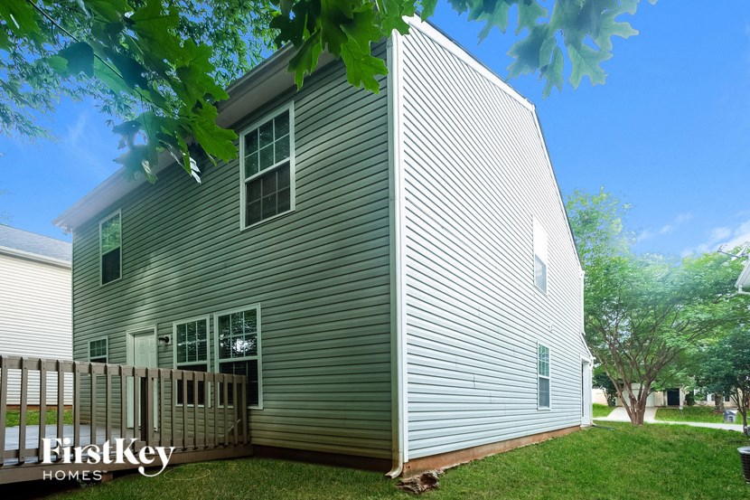 a large gray house with a wooden fence