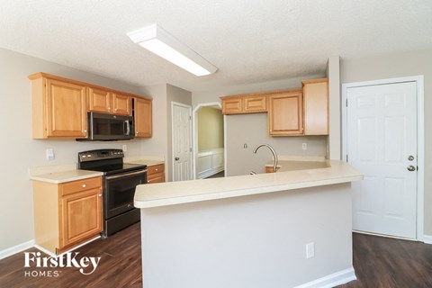 a kitchen with wooden cabinets and a white counter top