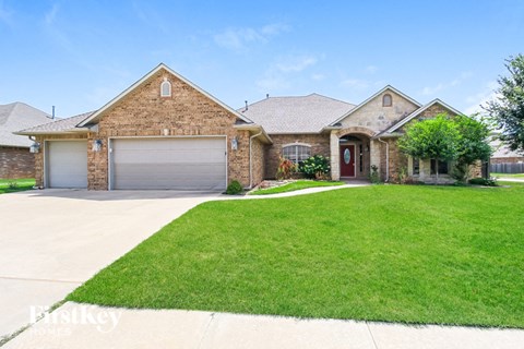 A brick house with a red door and a garage door.
