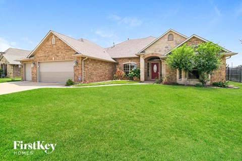 A house with a red door and a garage is for sale.