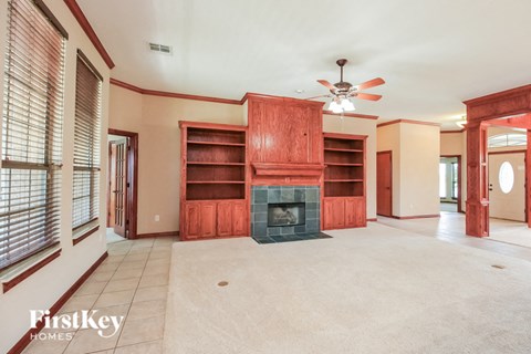 A living room with a fireplace and a fan.