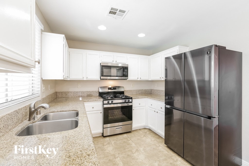 a kitchen with white cabinets and stainless steel appliances
