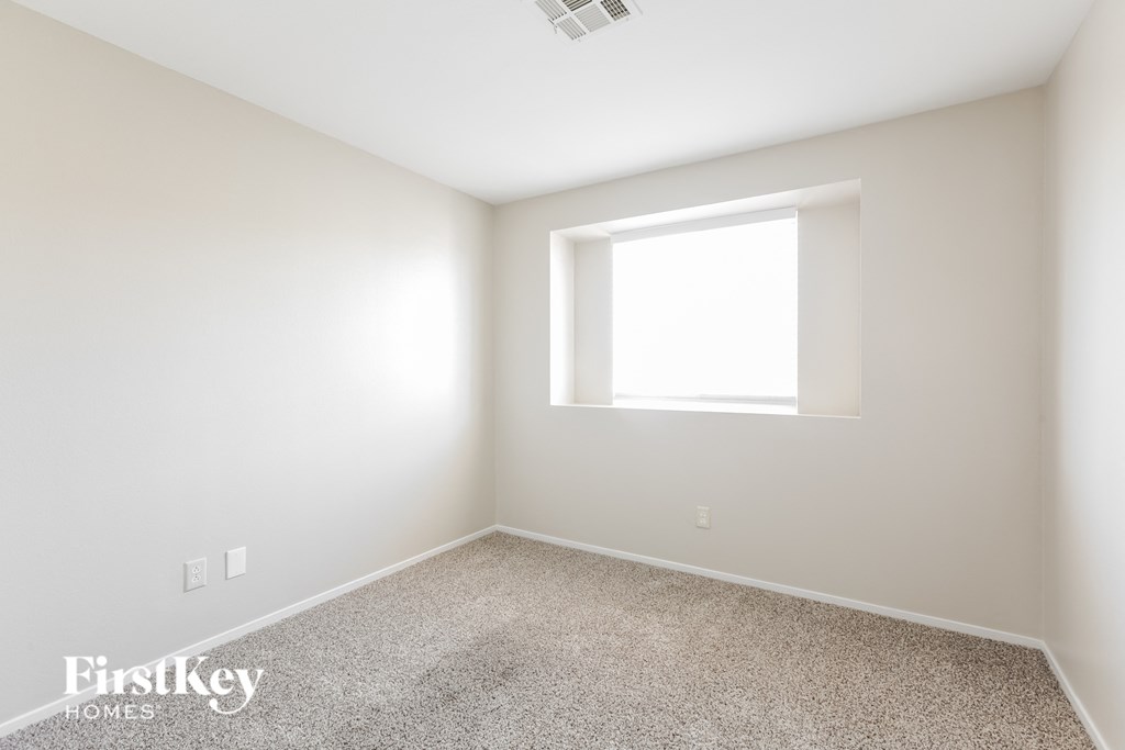 a white room with a window and a carpet