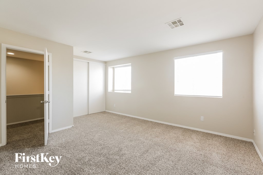 a bedroom with carpet and a door to a closet