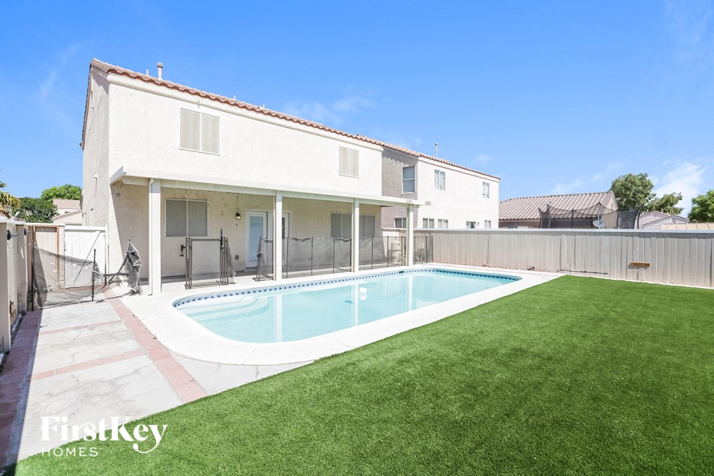 a backyard with a pool and a white house