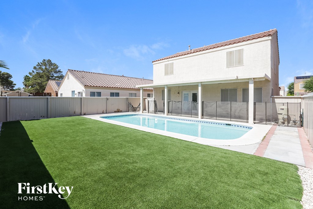 a backyard with a pool and a white house
