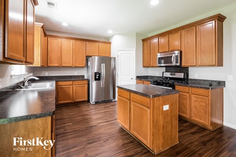 A kitchen with wooden cabinets and a refrigerator.