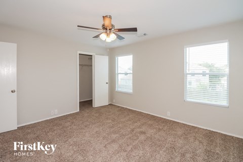 A spacious room with a ceiling fan and carpeted floor.