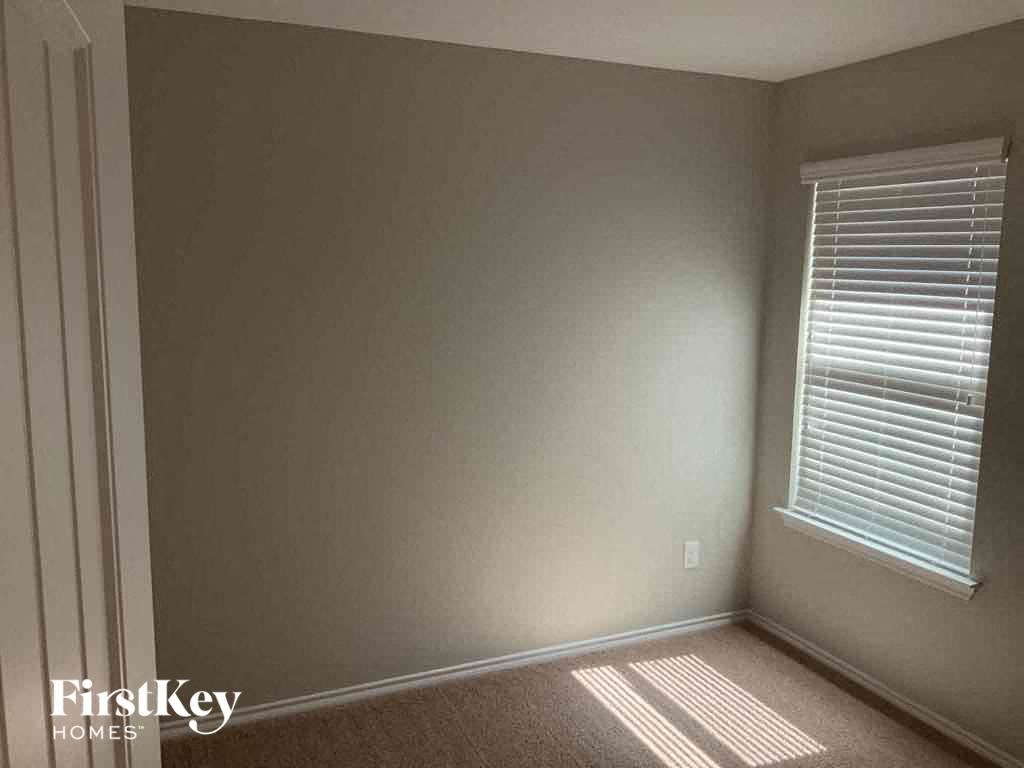 an empty room with a window and a white wall