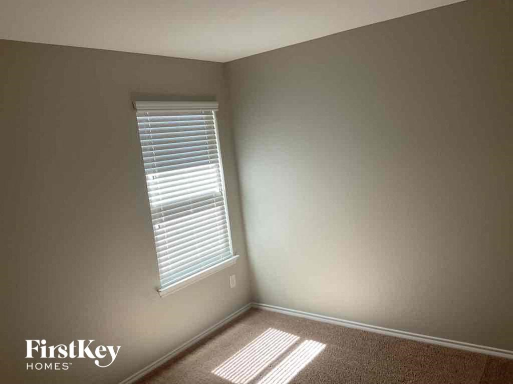 a small room with a window and a carpet