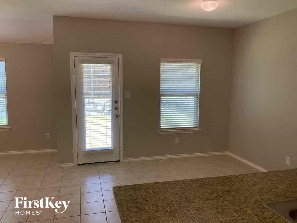 an empty living room with a white door and window