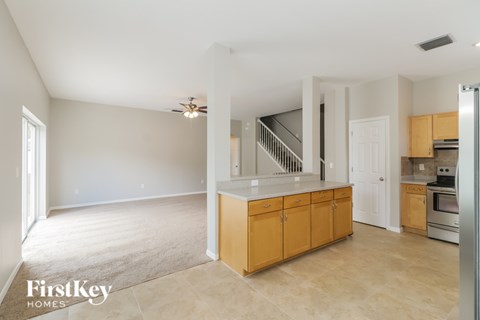 A kitchen area with wooden cabinets and a stainless steel refrigerator.