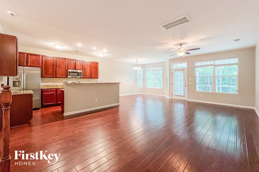 an empty living room and kitchen with wood floors