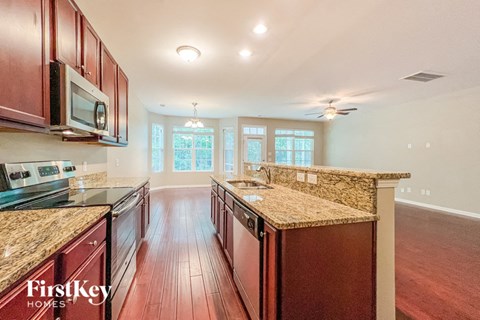 a kitchen with granite counter tops and wood floors