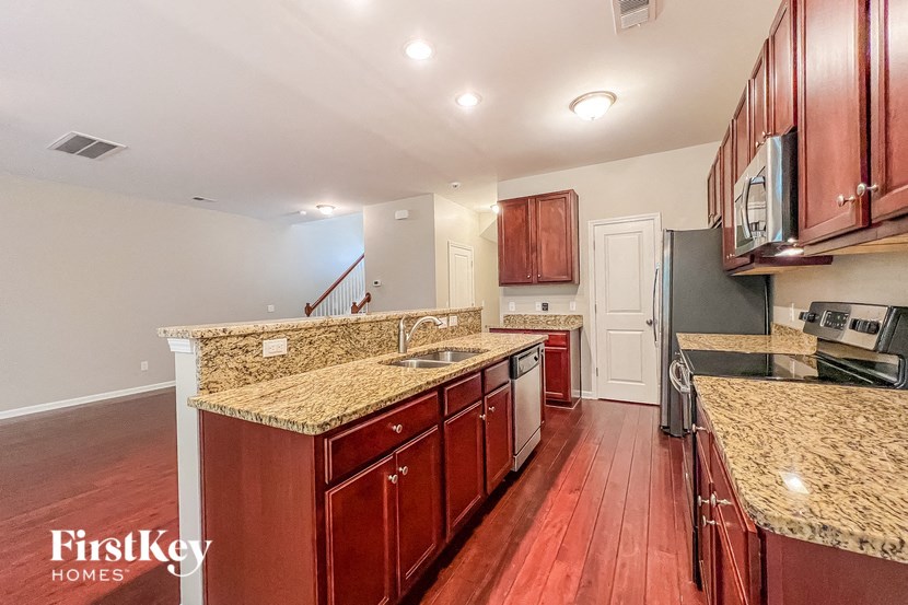 a kitchen with wood floors and granite counter tops
