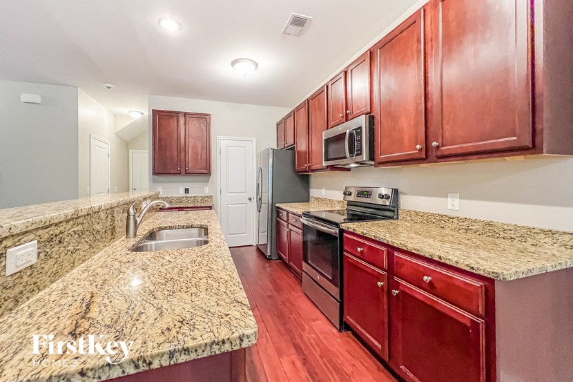 a kitchen with granite counter tops and wooden cabinets