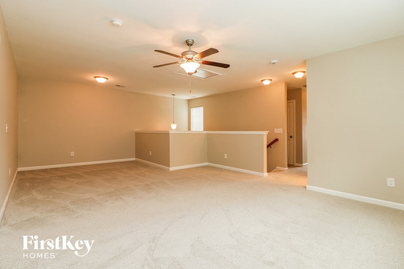 a empty living room with a ceiling fan