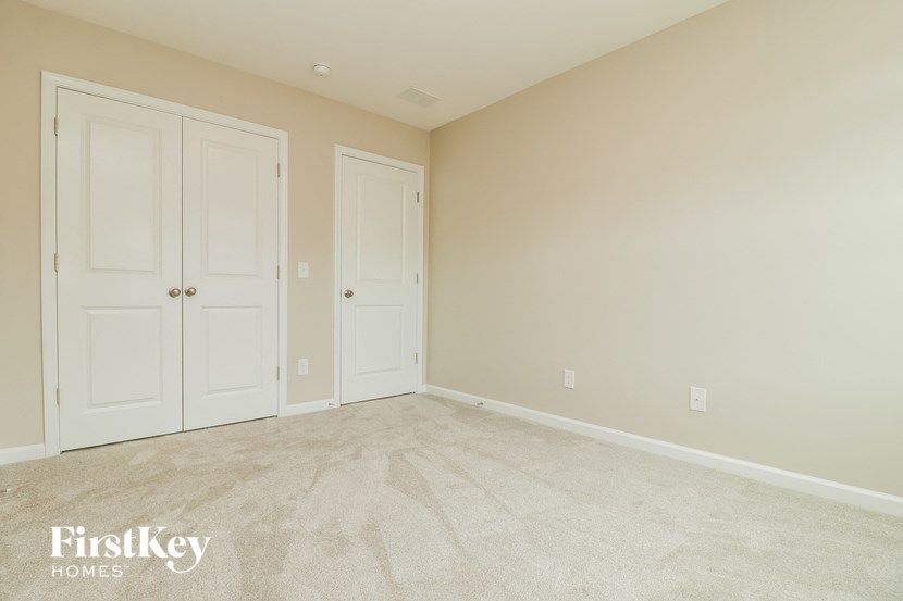 a bedroom with two doors and a carpeted floor