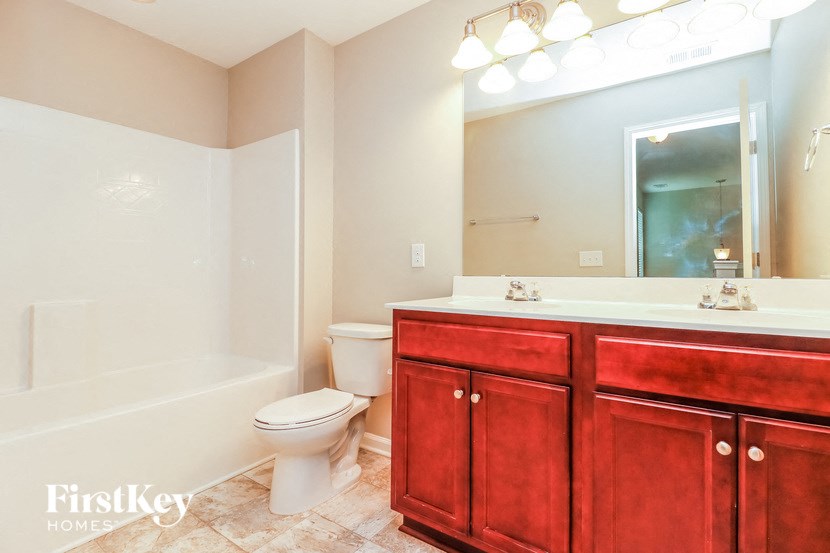 a bathroom with a sink toilet and a mirror