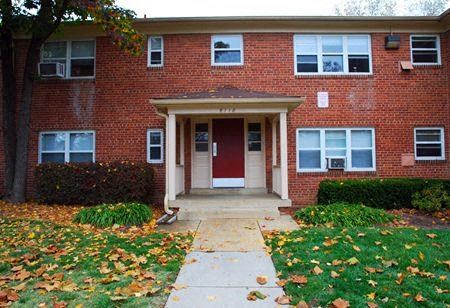 a red brick house with a sidewalk in front of it