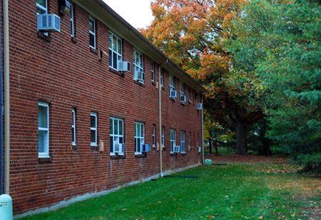 a red brick building with green grass and trees