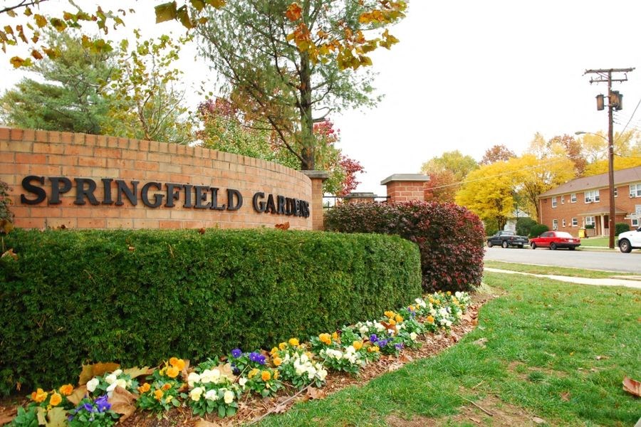 a sign for the game  in front of a garden of flowers