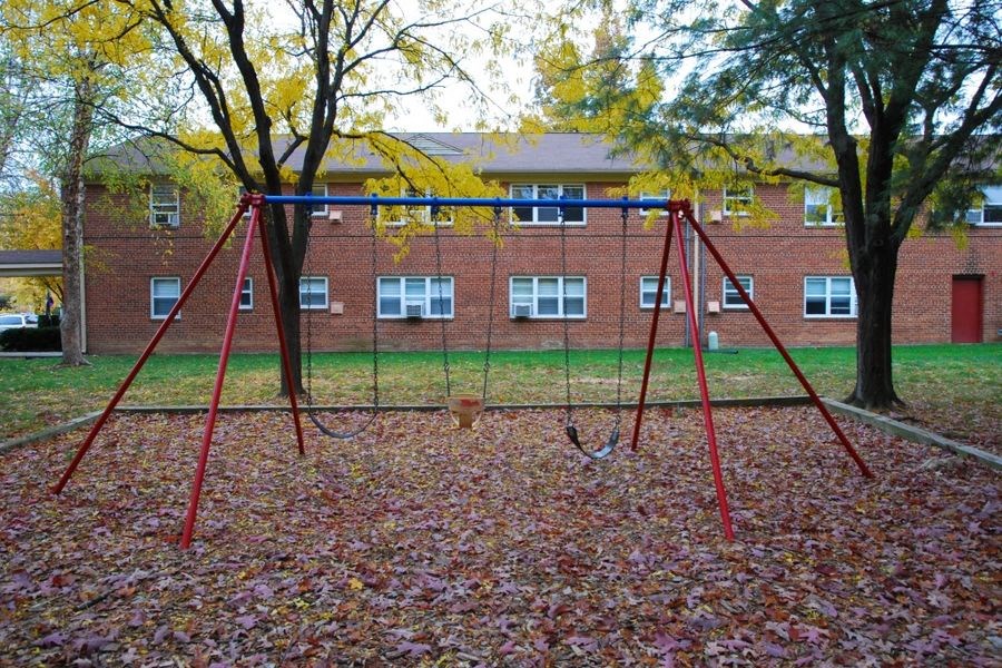 a swing set in a park in front of a building