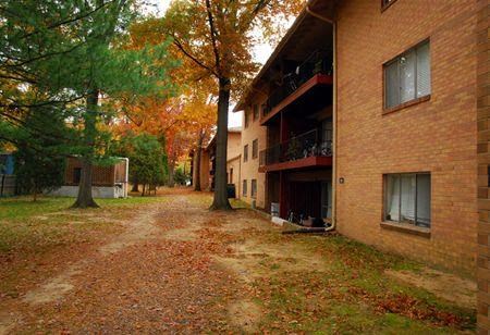 a dirt road in front of a brick building